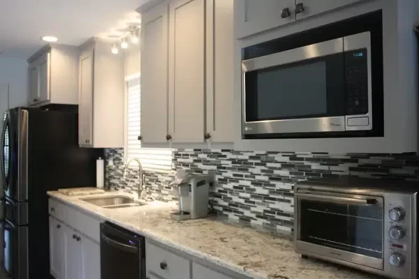 A Stove Top Oven Sitting Inside Of A Kitchen With Stainless Steel Appliances