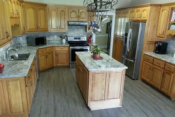 A Kitchen With Wooden Cabinets And A Wood Floor