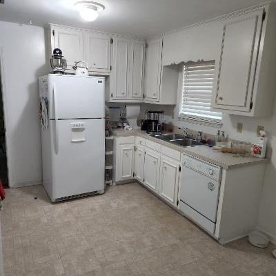 A Kitchen With A Sink And A Refrigerator