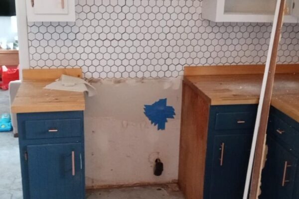 A Kitchen With A Stove Top Oven Sitting Inside Of A Room